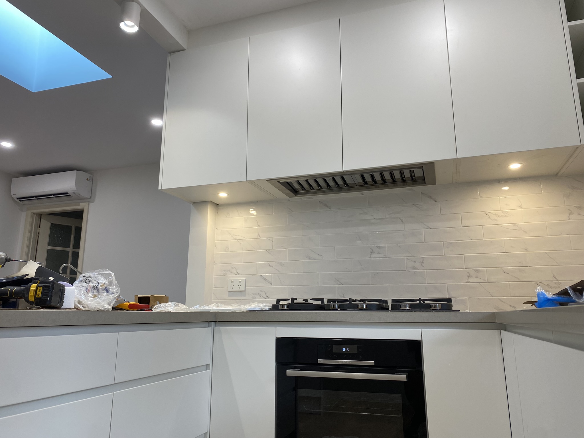 Electrical fit-off in a renovated kitchen with built-in oven, cooktop and downlights