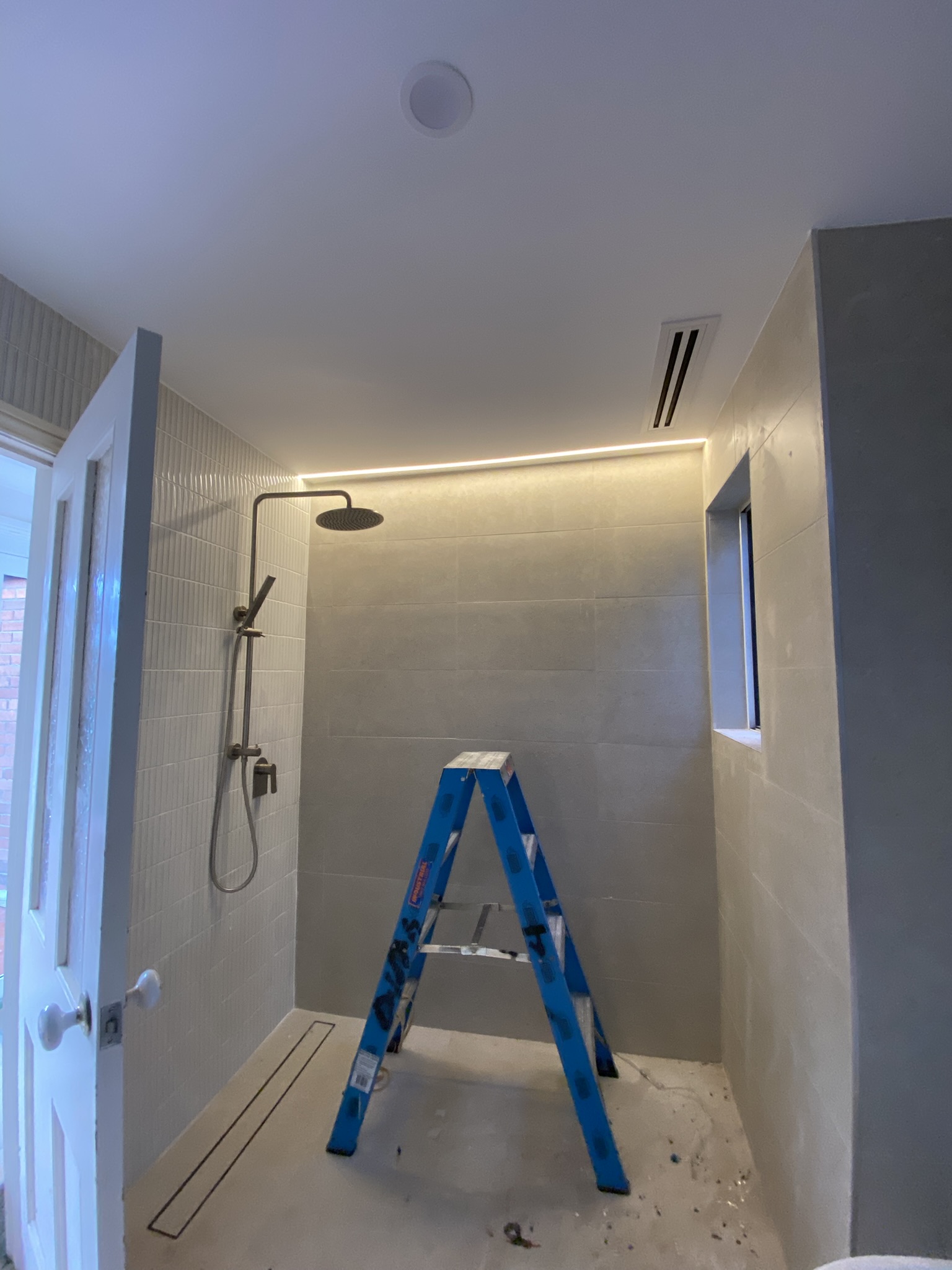 Recessed cove LED lighting installed along a bathroom ceiling line