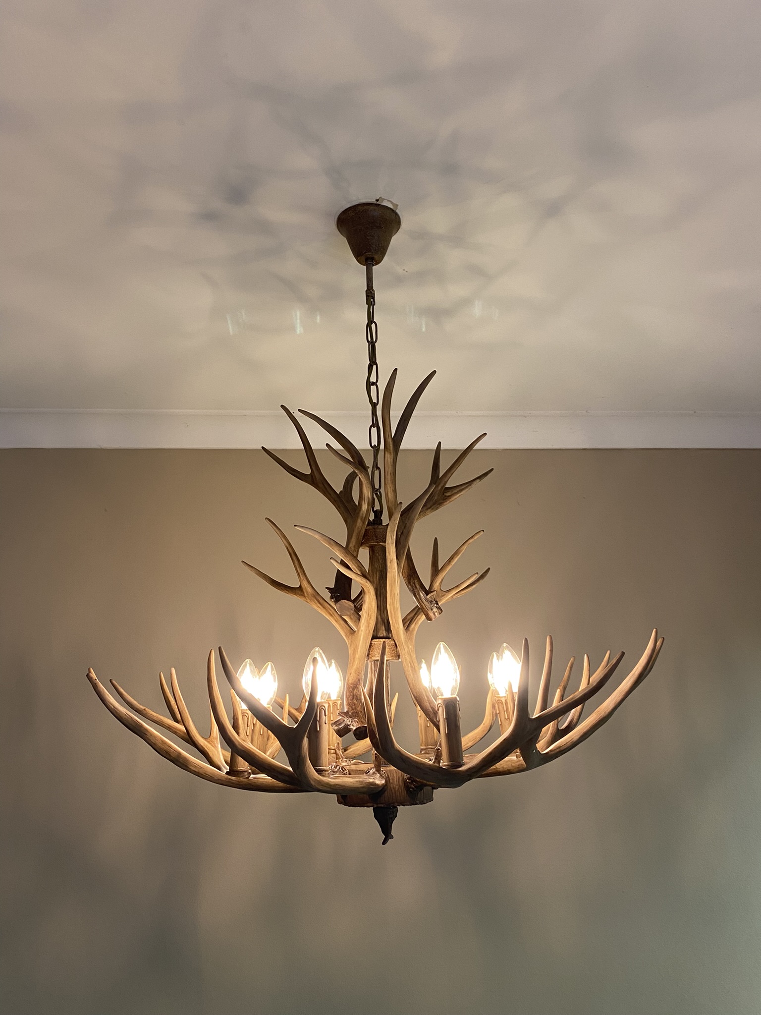 Decorative antler-style chandelier installed with hardwired ceiling connection