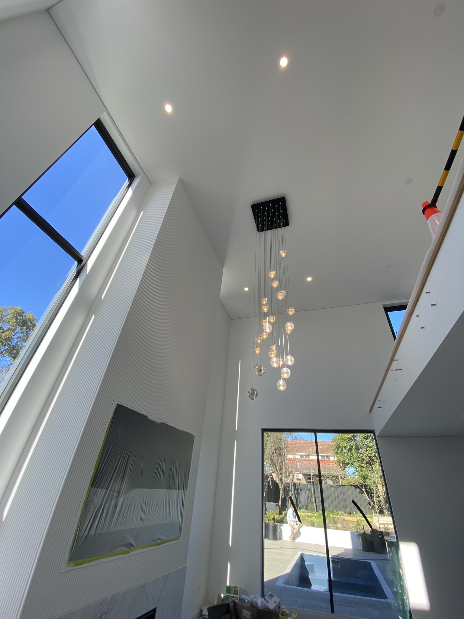 Multi-pendant glass orb chandelier in an open-plan double-height living room