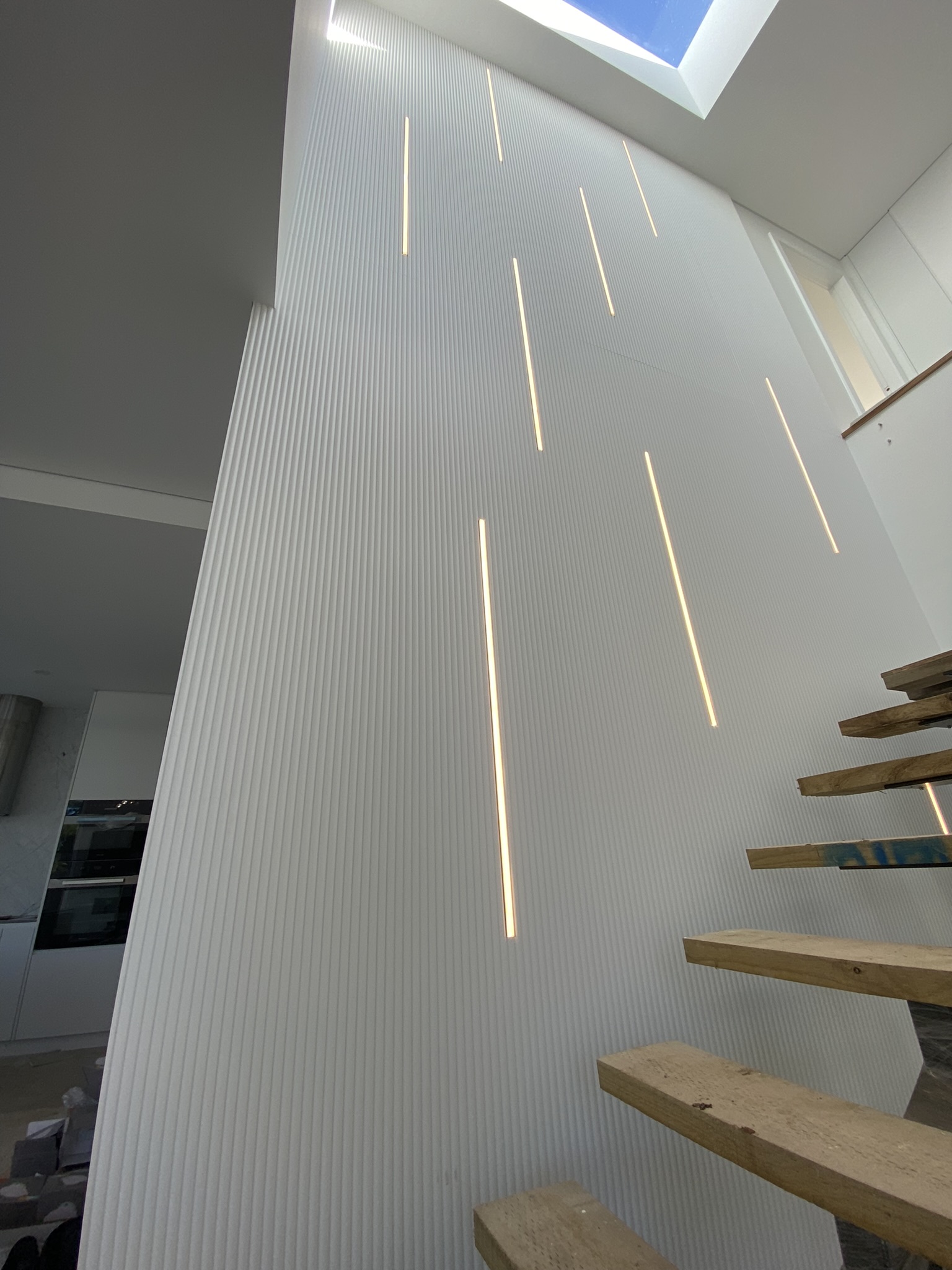 Vertical recessed LED feature wall lighting along a staircase