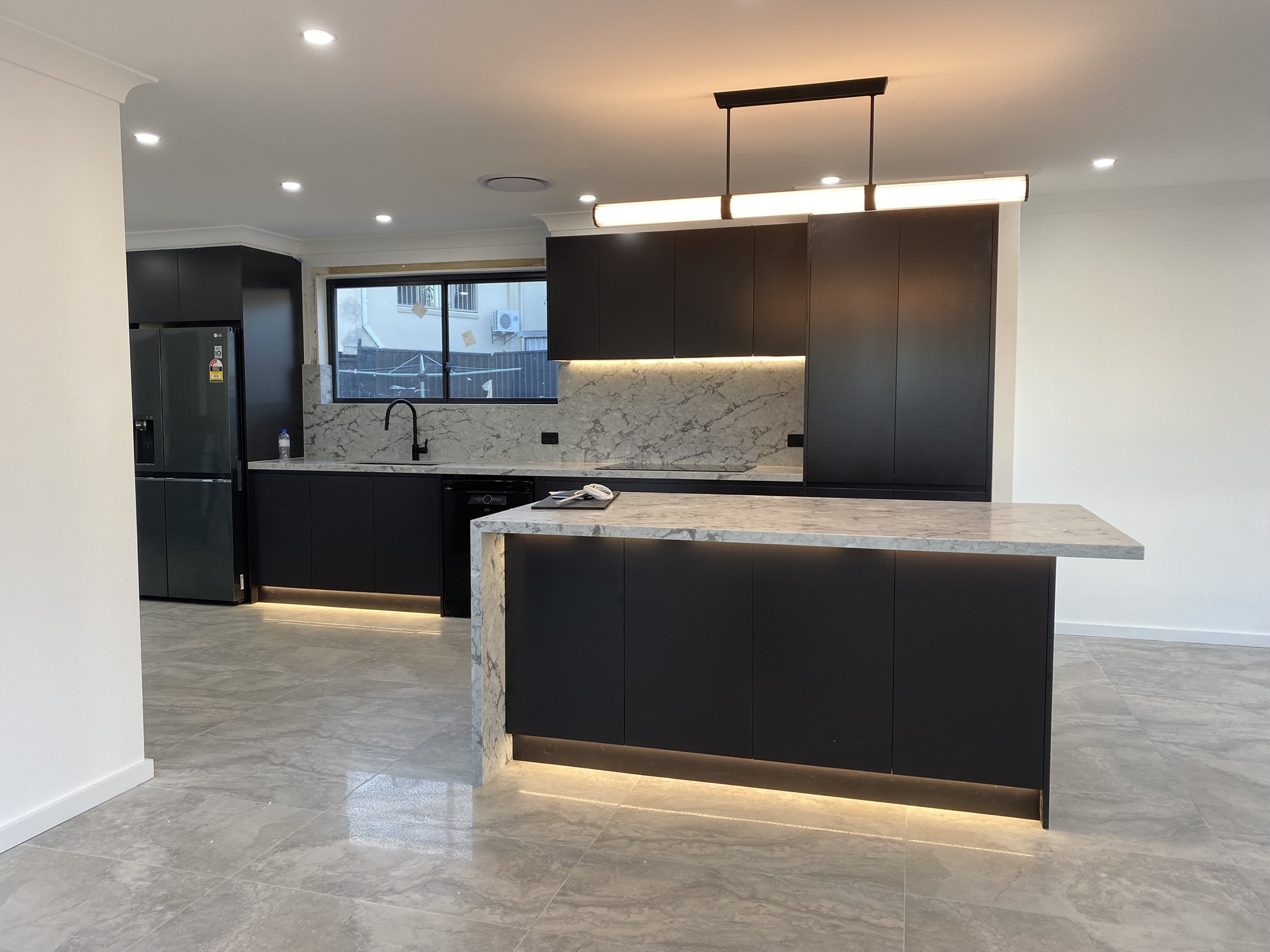 Kitchen island with suspended pendant light and under-benchtop LED strip lighting
