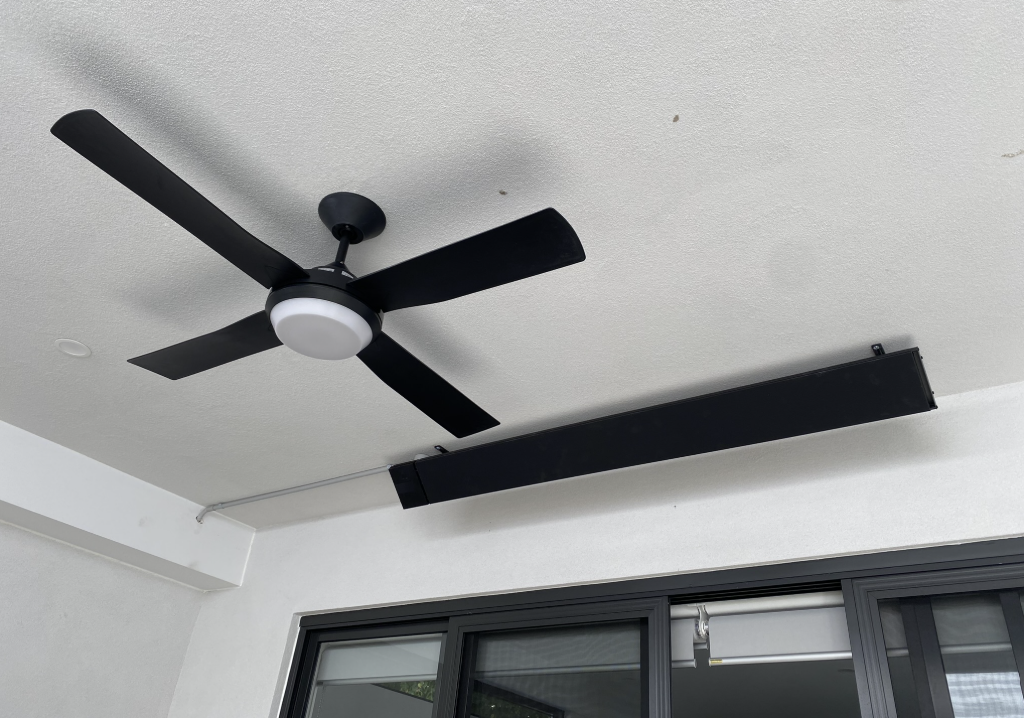Matte black ceiling fan and outdoor strip heater installed in a covered alfresco area